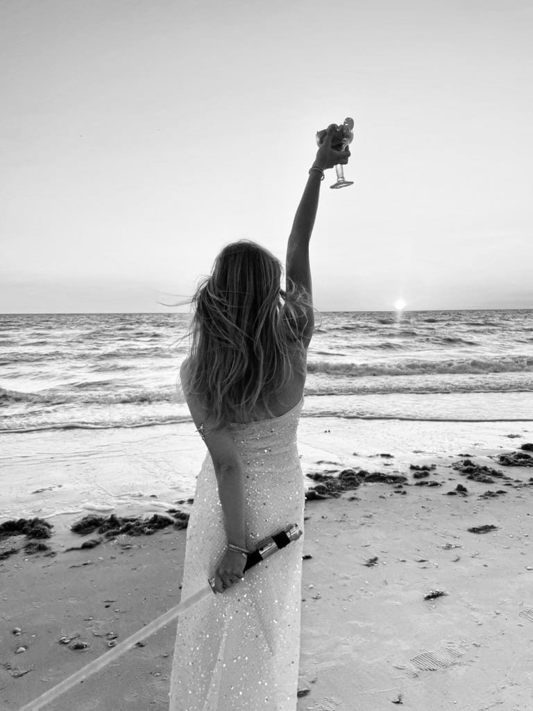 Lauren walking on beach, arm raised — About Me portrait