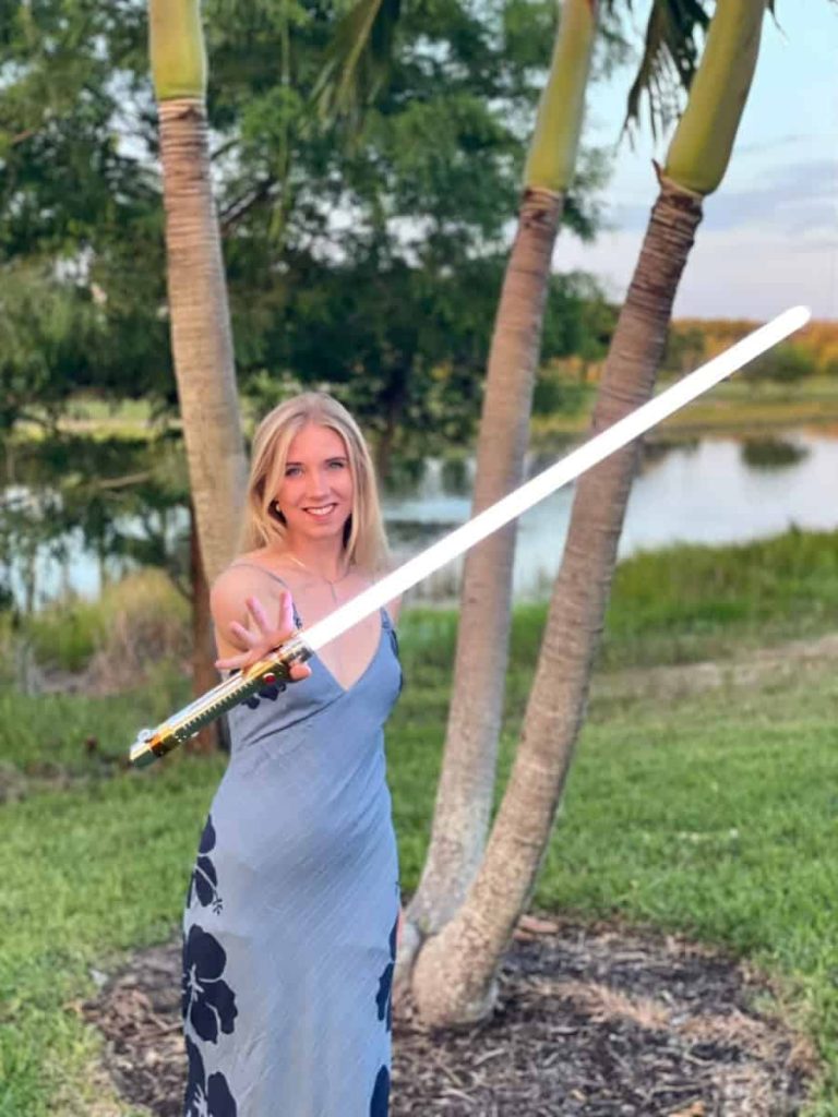 Lauren in blue dress with silver saber + palms — Q&A Spotlight portrait